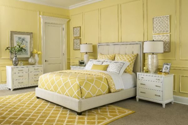 Yellow bedroom decor with a bed, dressers, and lamps